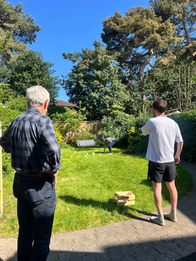 Playing Molkky (A Finnish Game Akin to Petanque and Skittles) In The Garden